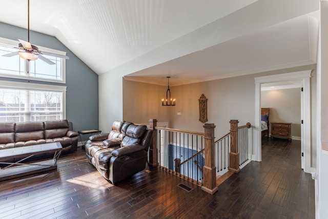 living room with crown molding, dark wood-type flooring, ceiling fan with notable chandelier, and high vaulted ceiling