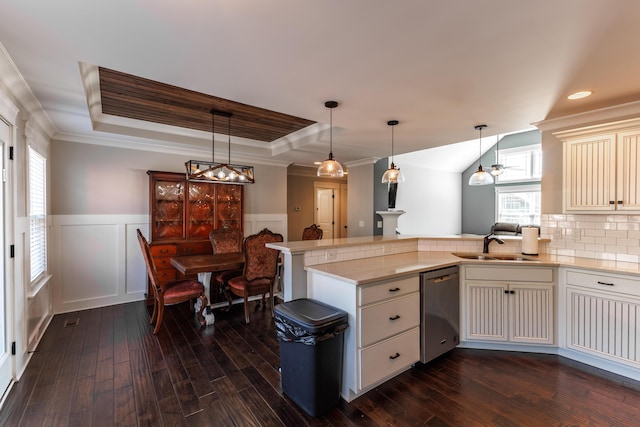 kitchen with a raised ceiling, hanging light fixtures, kitchen peninsula, and dishwasher