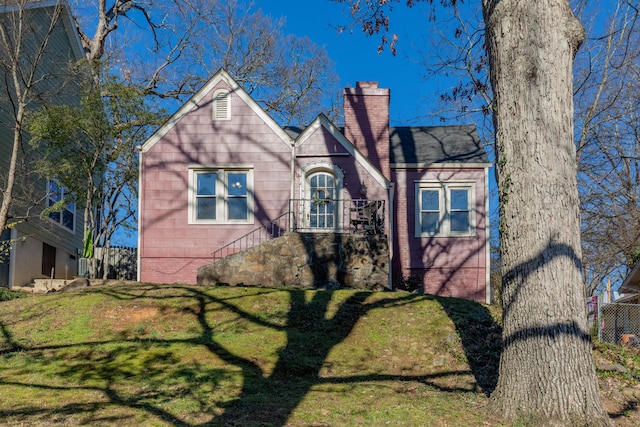 tudor home featuring a front lawn