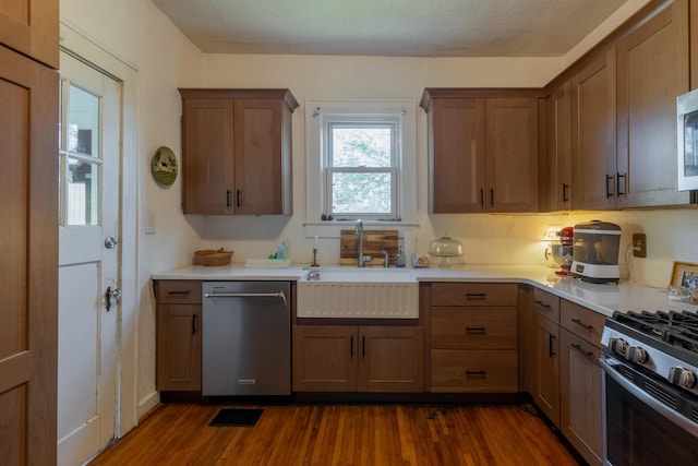 kitchen featuring dark wood-type flooring, stainless steel appliances, and sink