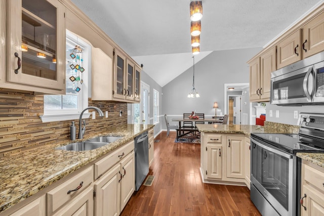 kitchen with hanging light fixtures, stainless steel appliances, sink, vaulted ceiling, and dark wood-type flooring