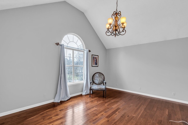 unfurnished room with lofted ceiling, an inviting chandelier, and wood-type flooring