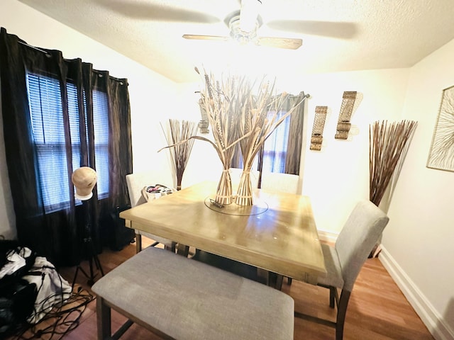 dining area with hardwood / wood-style floors, a textured ceiling, and ceiling fan