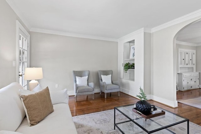 living room with crown molding, light hardwood / wood-style flooring, and built in features