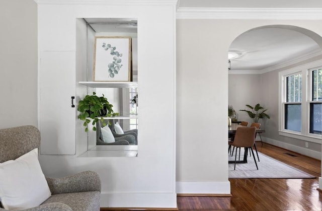 living area with hardwood / wood-style flooring and ornamental molding