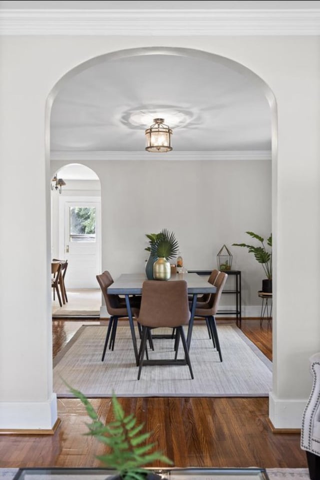 dining space with crown molding and hardwood / wood-style flooring