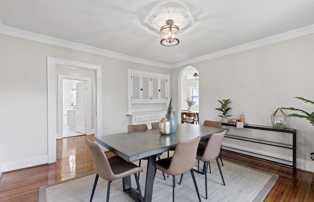 dining area with an inviting chandelier, hardwood / wood-style floors, and ornamental molding