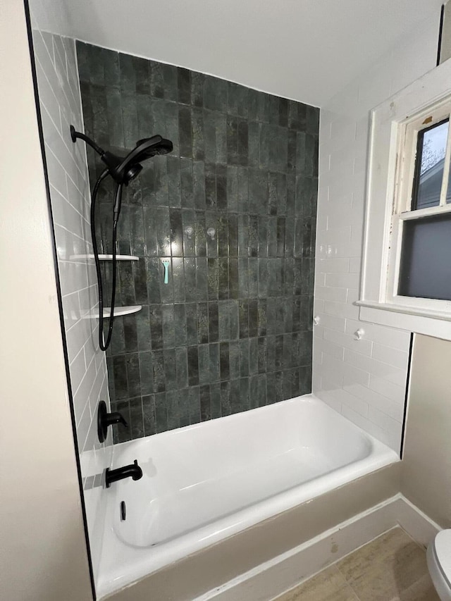 bathroom with tiled shower / bath and toilet