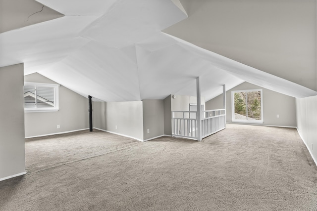 bonus room with lofted ceiling and carpet flooring