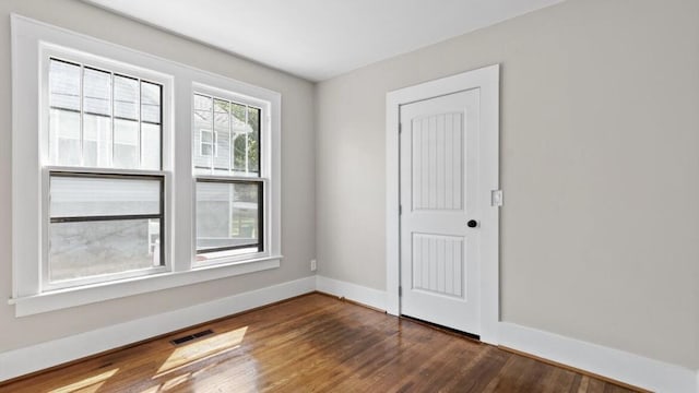 unfurnished room with dark hardwood / wood-style flooring