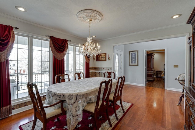 dining area featuring hardwood / wood-style flooring, ornamental molding, and a chandelier