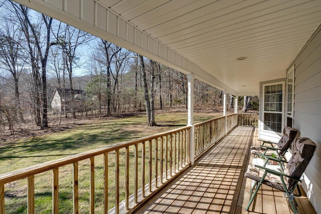 wooden terrace featuring a lawn