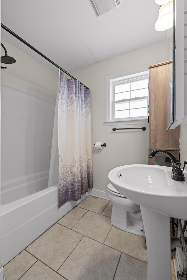 bathroom featuring toilet, tile patterned floors, and shower / tub combo with curtain