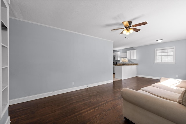 living room with sink, crown molding, dark wood-type flooring, ceiling fan, and a textured ceiling