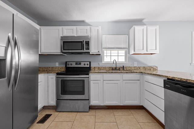 kitchen with white cabinetry, sink, stone countertops, and appliances with stainless steel finishes