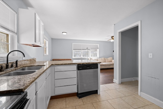 kitchen with a wealth of natural light, white cabinetry, sink, stainless steel dishwasher, and light tile patterned floors