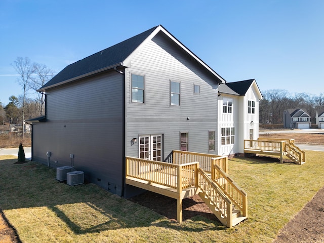 back of property with a wooden deck and a yard