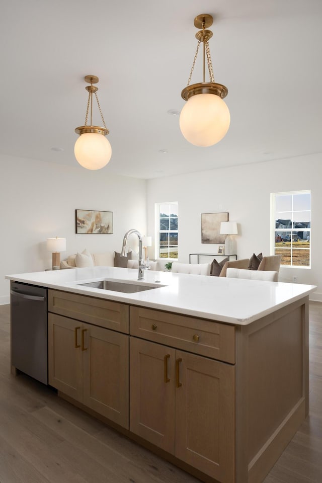 kitchen featuring sink, hanging light fixtures, stainless steel dishwasher, dark hardwood / wood-style floors, and a kitchen island with sink