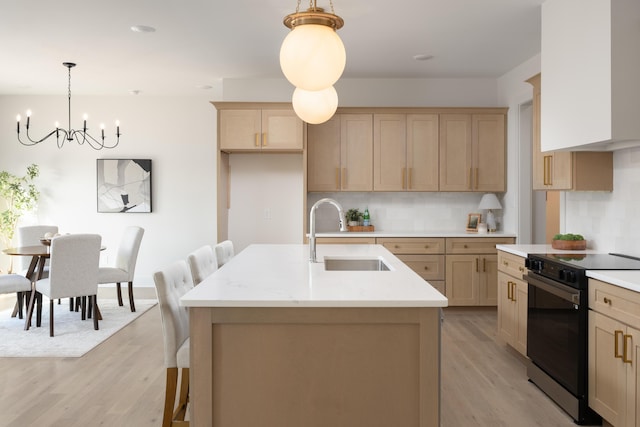 kitchen featuring an island with sink, sink, black range with electric cooktop, and light brown cabinets