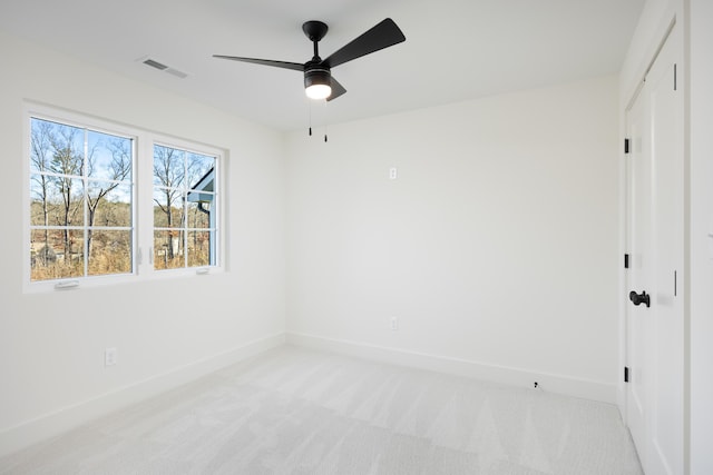 unfurnished room with ceiling fan and light carpet