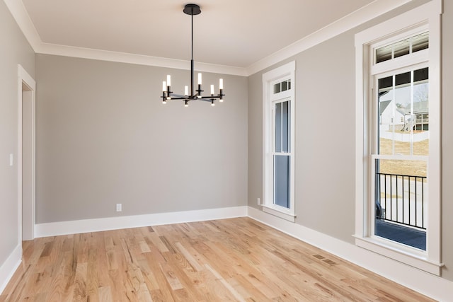 unfurnished room with a chandelier, light wood-style floors, visible vents, and crown molding