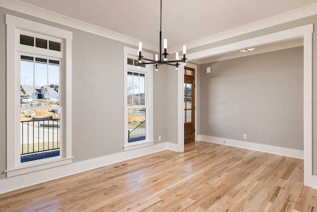 unfurnished dining area with baseboards, light wood-type flooring, visible vents, and an inviting chandelier