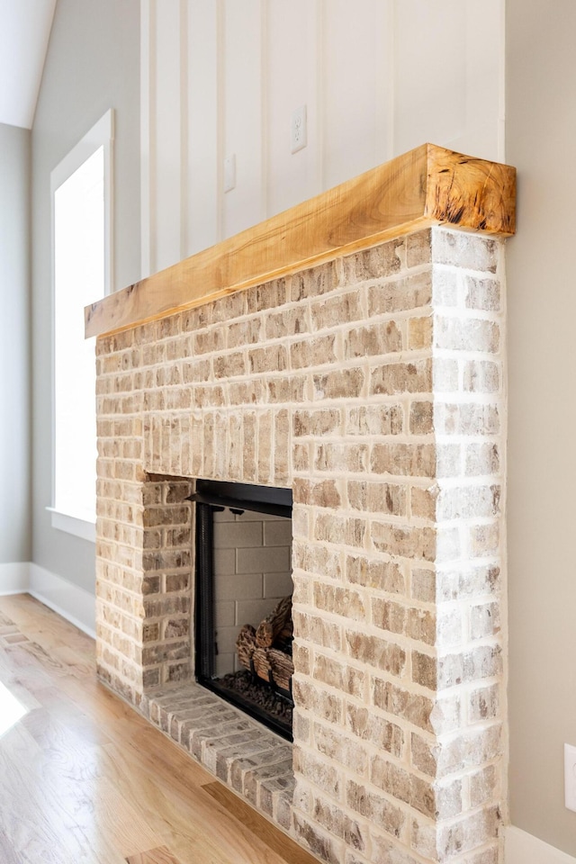 interior details with a brick fireplace and wood finished floors