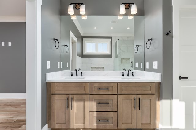 full bathroom featuring double vanity, ornamental molding, a stall shower, and a sink