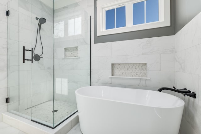 full bath featuring a stall shower, tile walls, and a freestanding bath