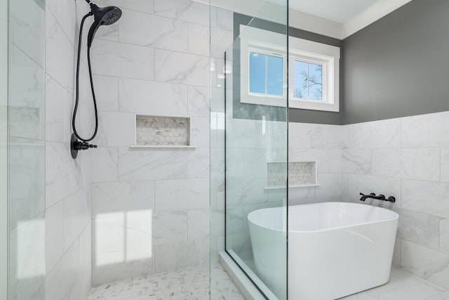 bathroom featuring a freestanding tub, a tile shower, and tile walls