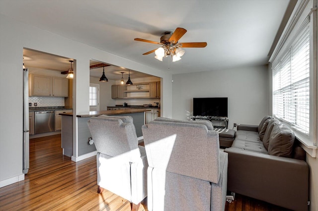 living room with ceiling fan, a healthy amount of sunlight, and light hardwood / wood-style flooring