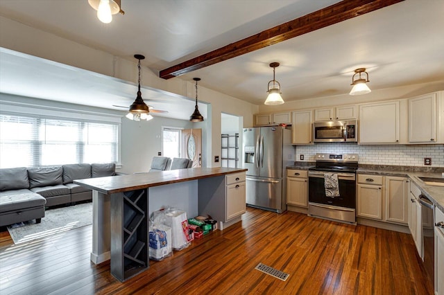 kitchen featuring stainless steel appliances, hanging light fixtures, backsplash, and dark hardwood / wood-style flooring