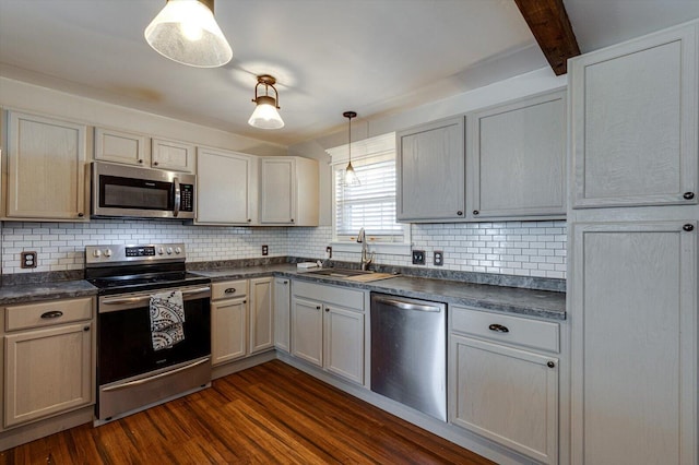 kitchen featuring sink, appliances with stainless steel finishes, tasteful backsplash, dark hardwood / wood-style flooring, and decorative light fixtures