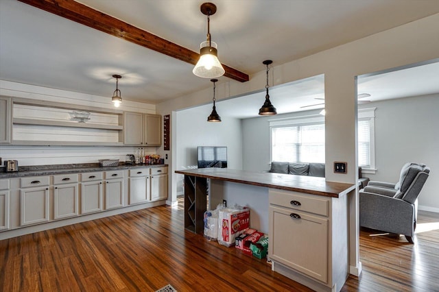 kitchen with pendant lighting, butcher block countertops, beam ceiling, and dark wood-type flooring