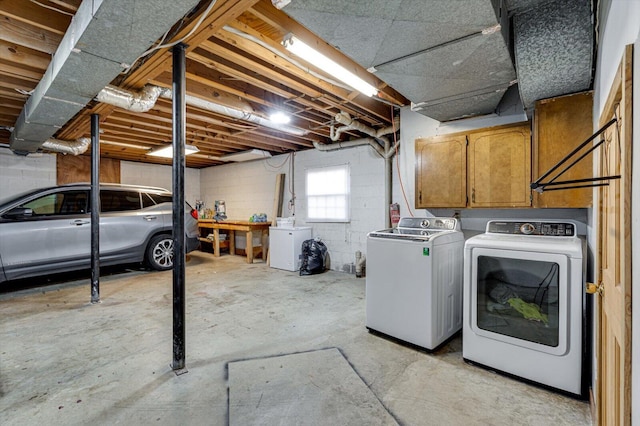 basement featuring fridge and washer and clothes dryer