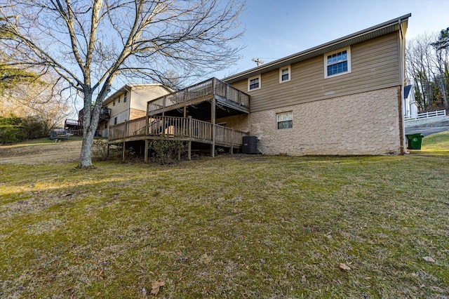 rear view of property featuring cooling unit, a yard, and a deck