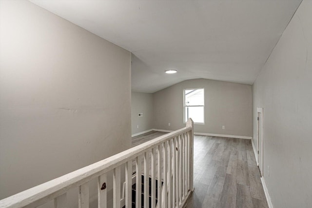 corridor with vaulted ceiling and light wood-type flooring