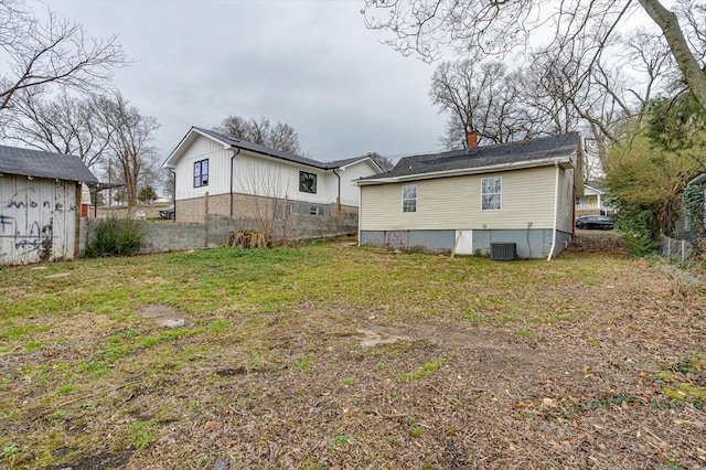 back of property with cooling unit and a lawn