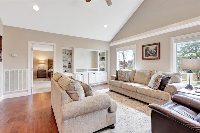 living room featuring ceiling fan, hardwood / wood-style floors, built in features, and high vaulted ceiling