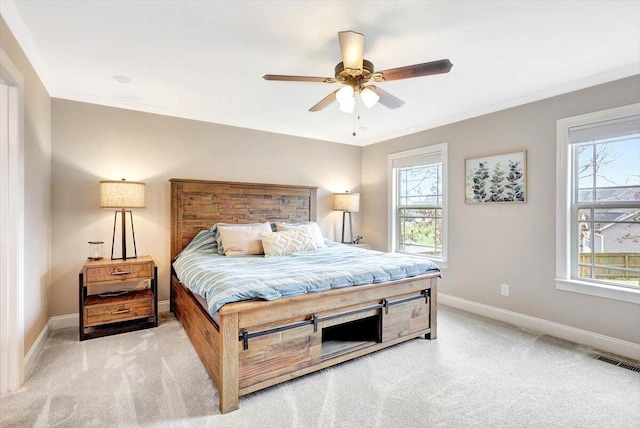 bedroom featuring ornamental molding, light colored carpet, and ceiling fan