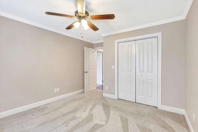 unfurnished bedroom with crown molding, light colored carpet, ceiling fan, and a closet