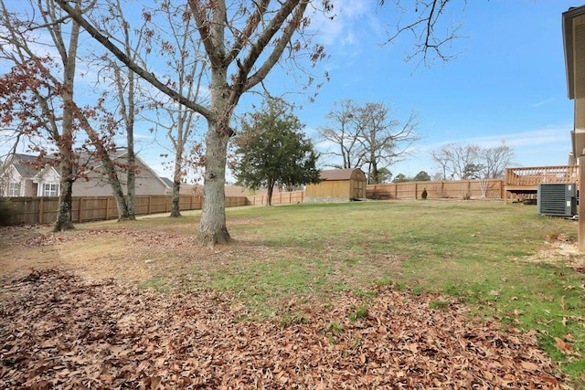 view of yard featuring a storage shed and central AC unit