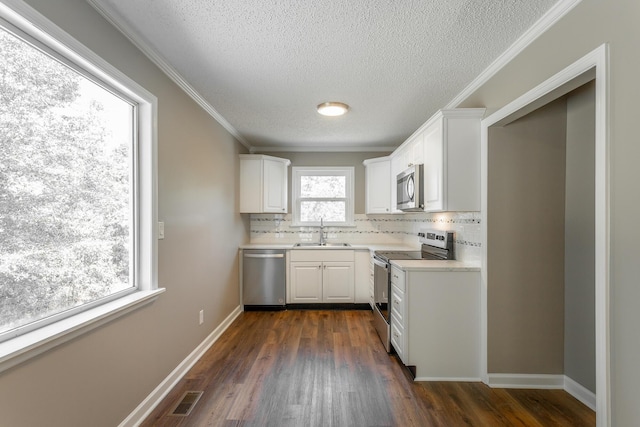 kitchen featuring appliances with stainless steel finishes, sink, decorative backsplash, and white cabinets