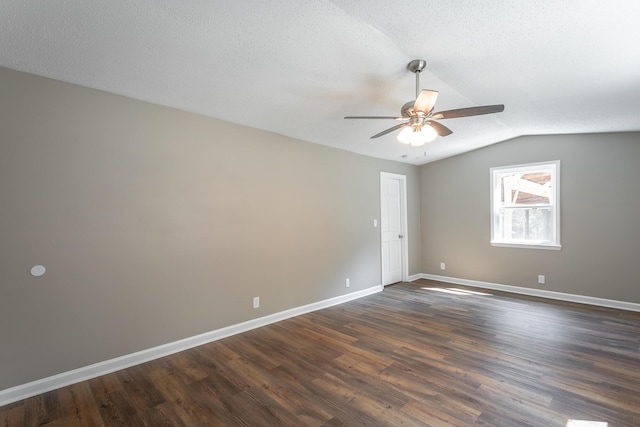 spare room featuring ceiling fan, lofted ceiling, dark wood-type flooring, and a textured ceiling