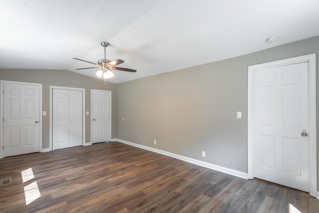 unfurnished bedroom with lofted ceiling, dark hardwood / wood-style floors, and ceiling fan