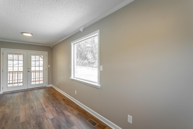 doorway with dark wood-type flooring, ornamental molding, french doors, and a textured ceiling