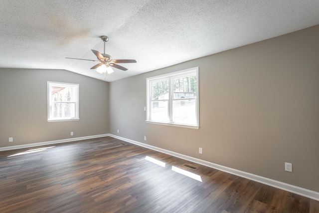 empty room with lofted ceiling, ceiling fan, dark wood-type flooring, and a textured ceiling