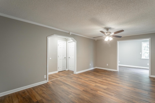 spare room with dark wood-type flooring, ceiling fan, ornamental molding, and a textured ceiling