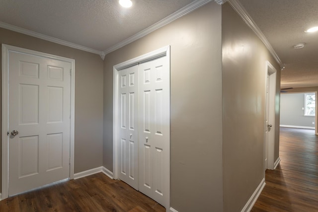 corridor with dark wood-type flooring, ornamental molding, and a textured ceiling