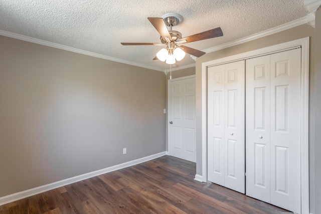 unfurnished bedroom with ceiling fan, ornamental molding, a textured ceiling, dark hardwood / wood-style flooring, and a closet